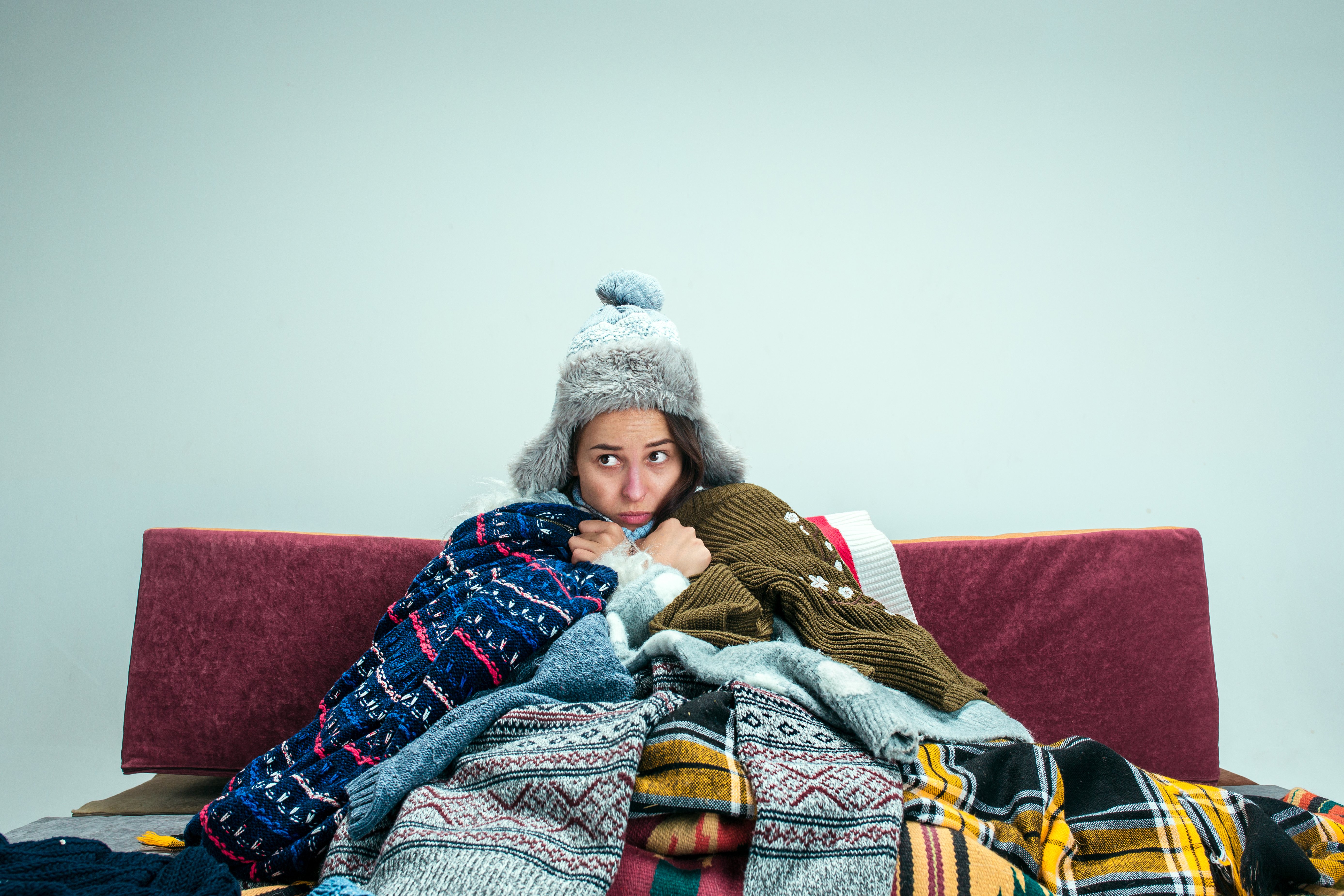 young-sick-woman-with-flue-sitting-sofa-home-studio-covered-with-knitted-warm-clothes-illness-influenza-pain-concept-relaxation-home-healthcare-concepts
